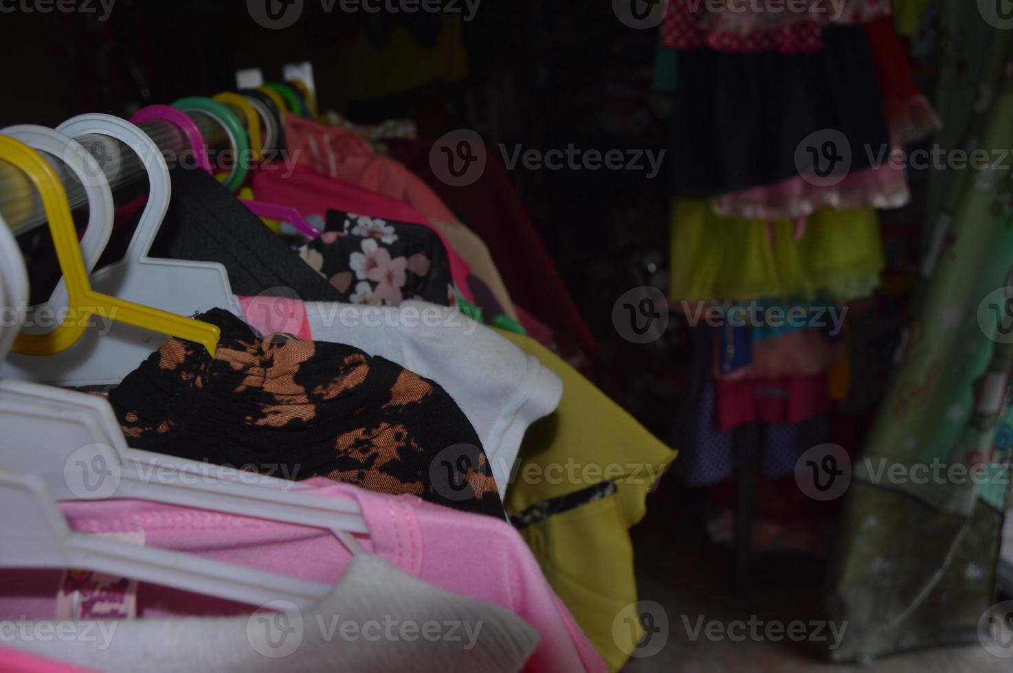 clothes hanging in the shop with a dark room background photo