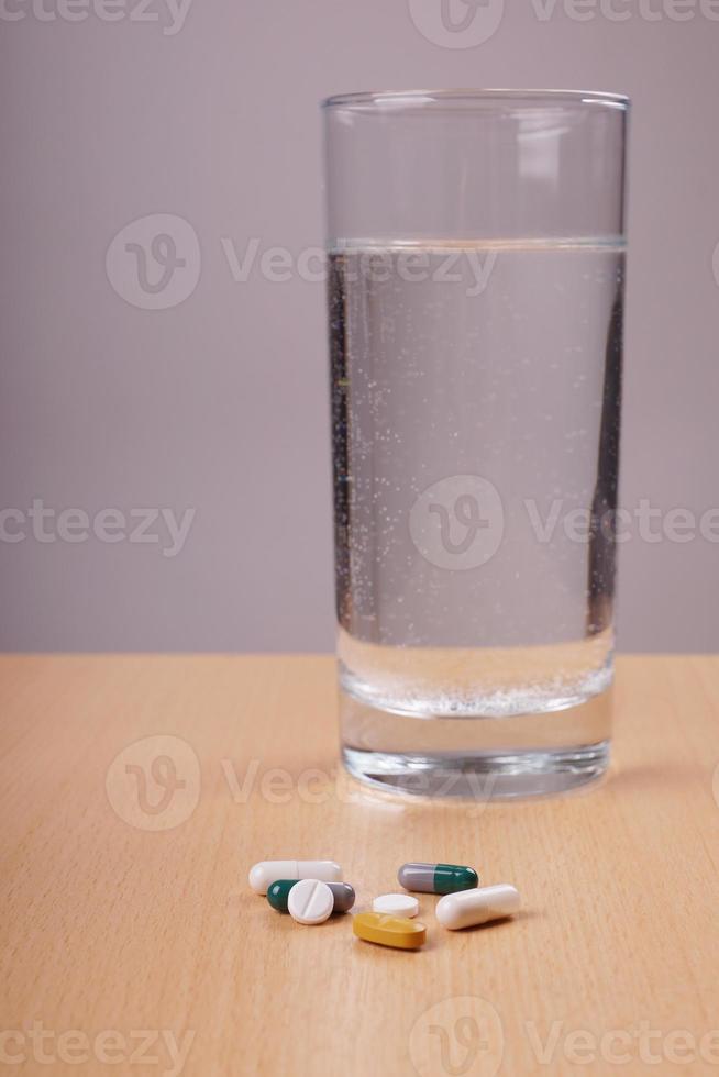 pastillas de medicación y vaso de agua foto
