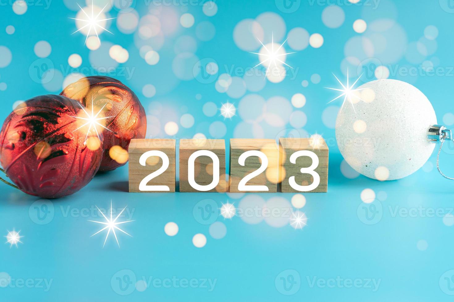The wooden cube with the word 2022 changes to 2023. New Year Christmas Day. Concept on bokeh and blue background. Close up and copy space on top and under for design or text. photo