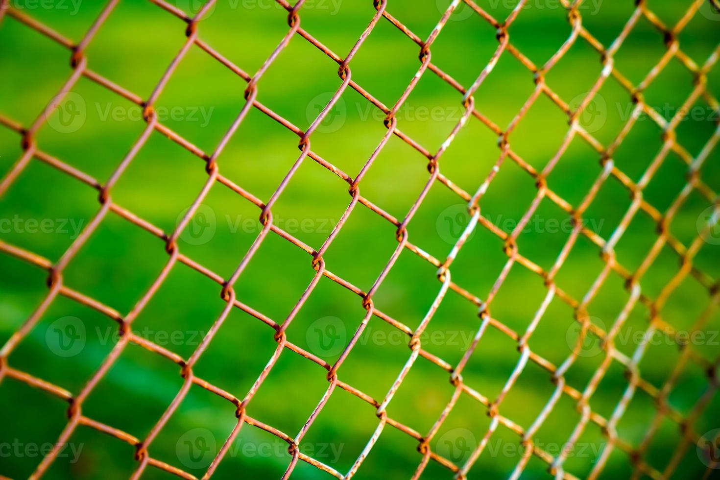 Rust steel net with blur football field. photo