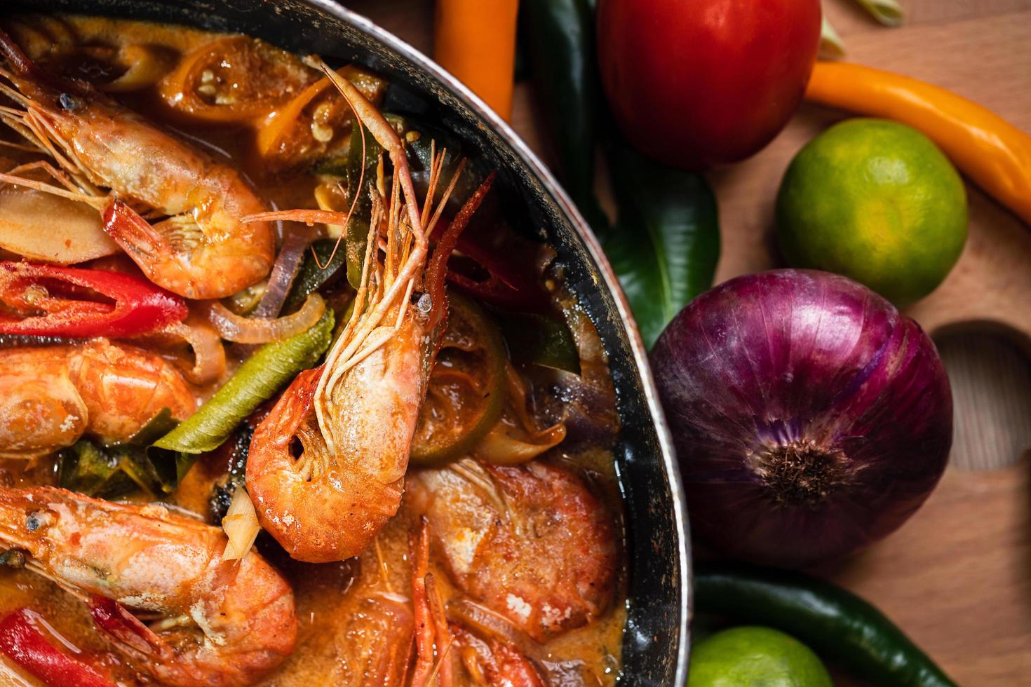 Tom Yum Goong or Tom Yum Kung, Thai hot and sour shrimp soup in pan. Popular Thai food in Thai cuisine restaurant. Shrimp and Spices with lemongrass, lemon, galangal, chili in coconut milk. Closeup photo