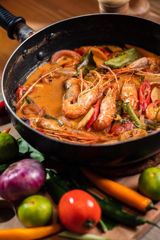 Tom Yum Goong or Tom Yum Kung, Thai hot and sour shrimp soup in pan. Popular Thai food in Thai cuisine restaurant. Shrimp and Spices with lemongrass, lemon, galangal, chili in coconut milk. Closeup photo