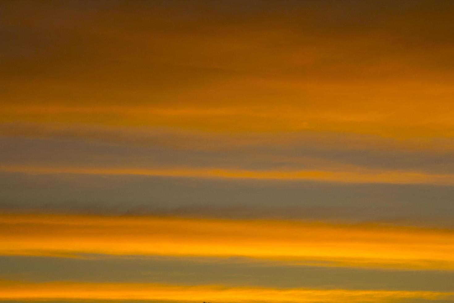 The sky is a horizontal line of yellow-orange and colorful colors in the beautiful evening in the midst of nature which is peaceful, warm and romantic in the countryside and is extremely beautiful. photo