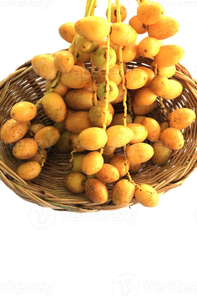 Ripe yellow dates are organically grown, sweet and delicious, and fresh in woven baskets - on a white background. photo