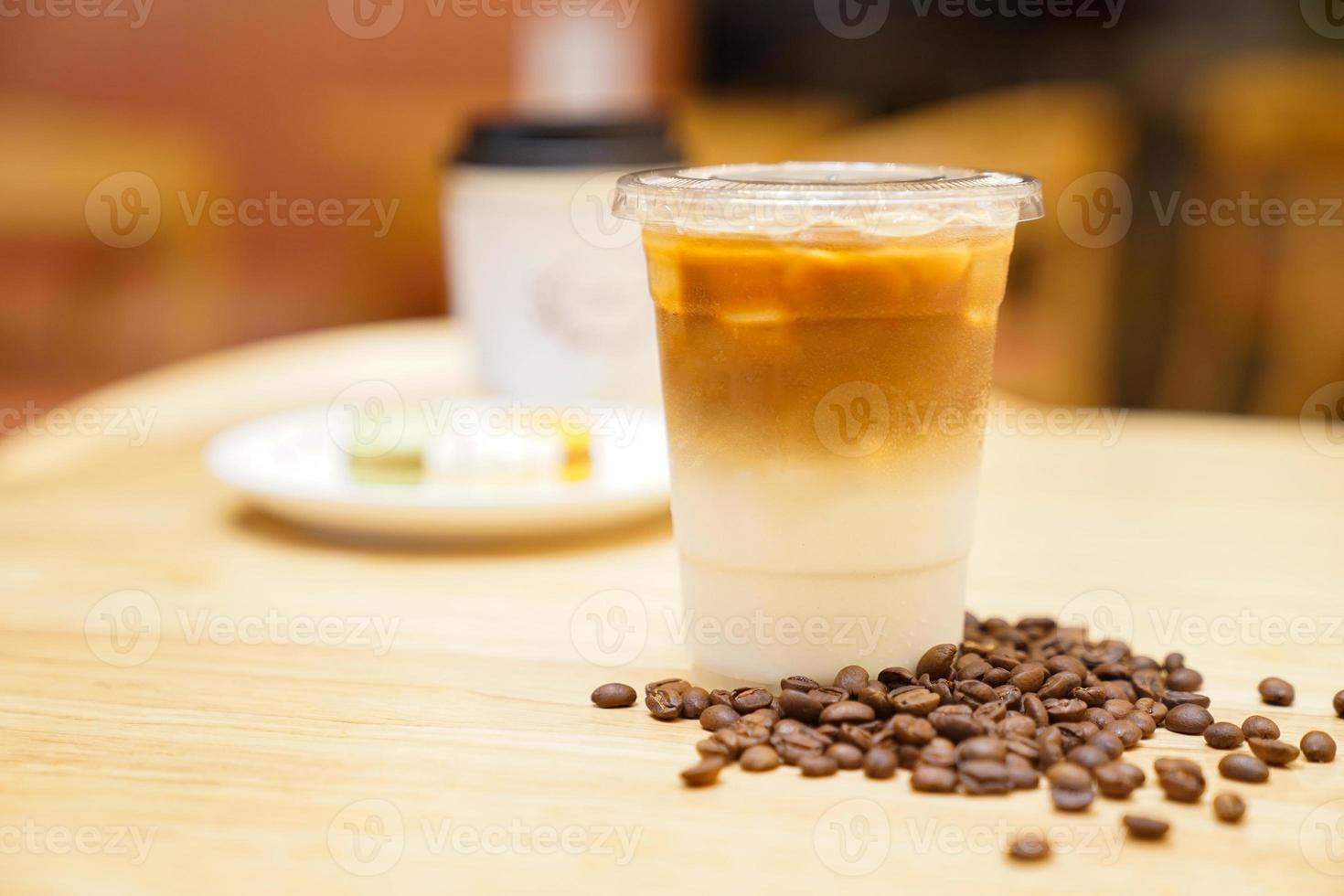 Take away Latte with Coffee bean around on the wood table photo