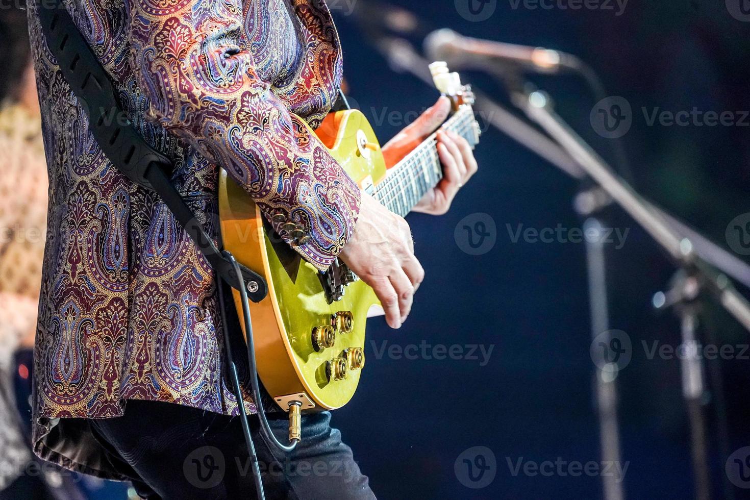 guitarra estilo dedo, de artista experto con experiencia con traje colorido. foto