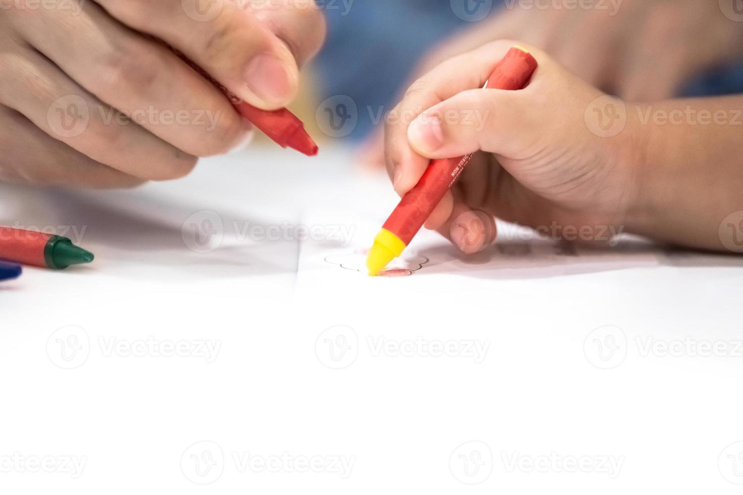 little girl plays and learns to coloring Crayon on the paper in the ice-cream restaurant., Bangkok, Thailand. photo