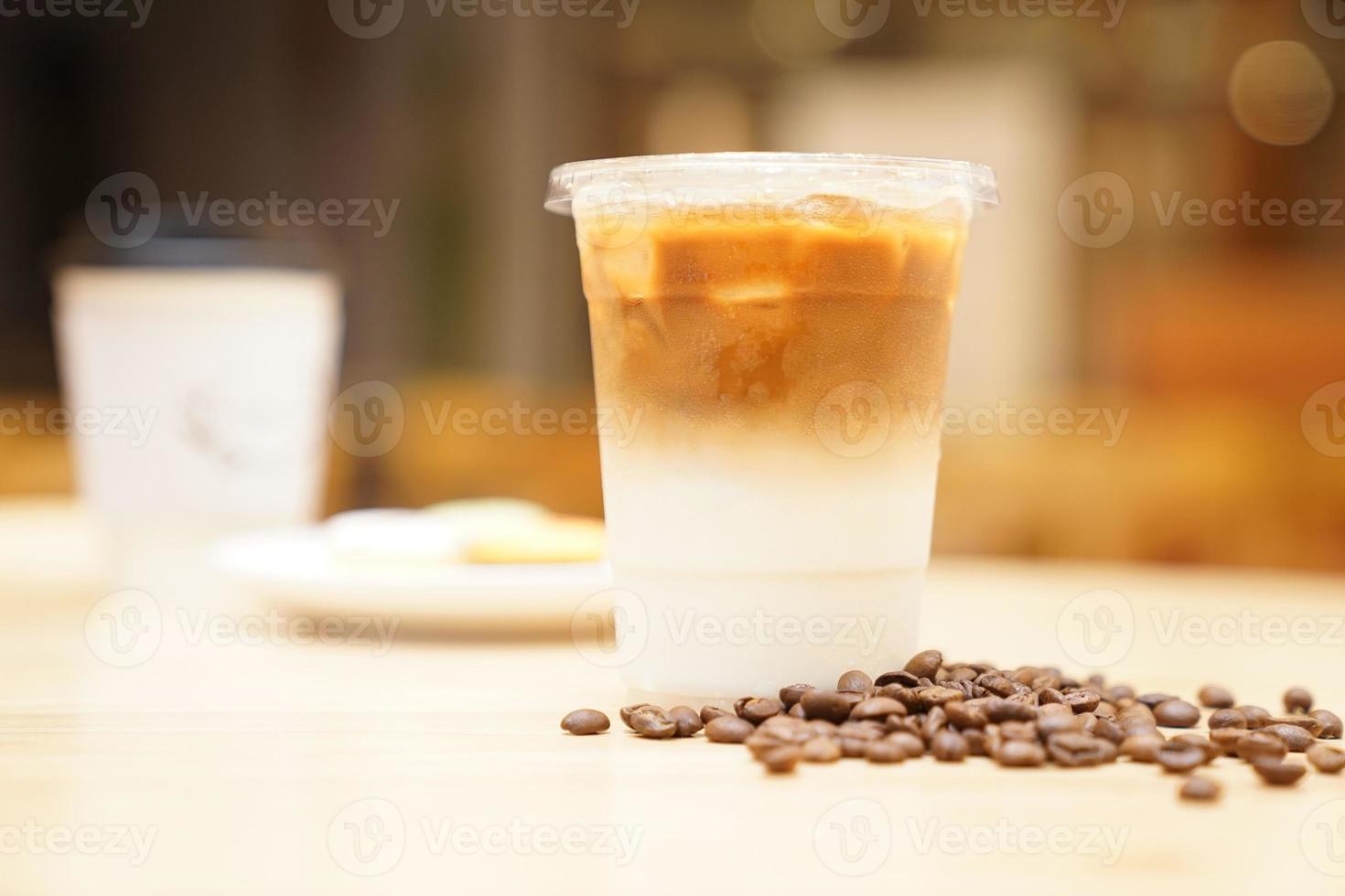 Take away Latte with Coffee bean around on the wood table photo