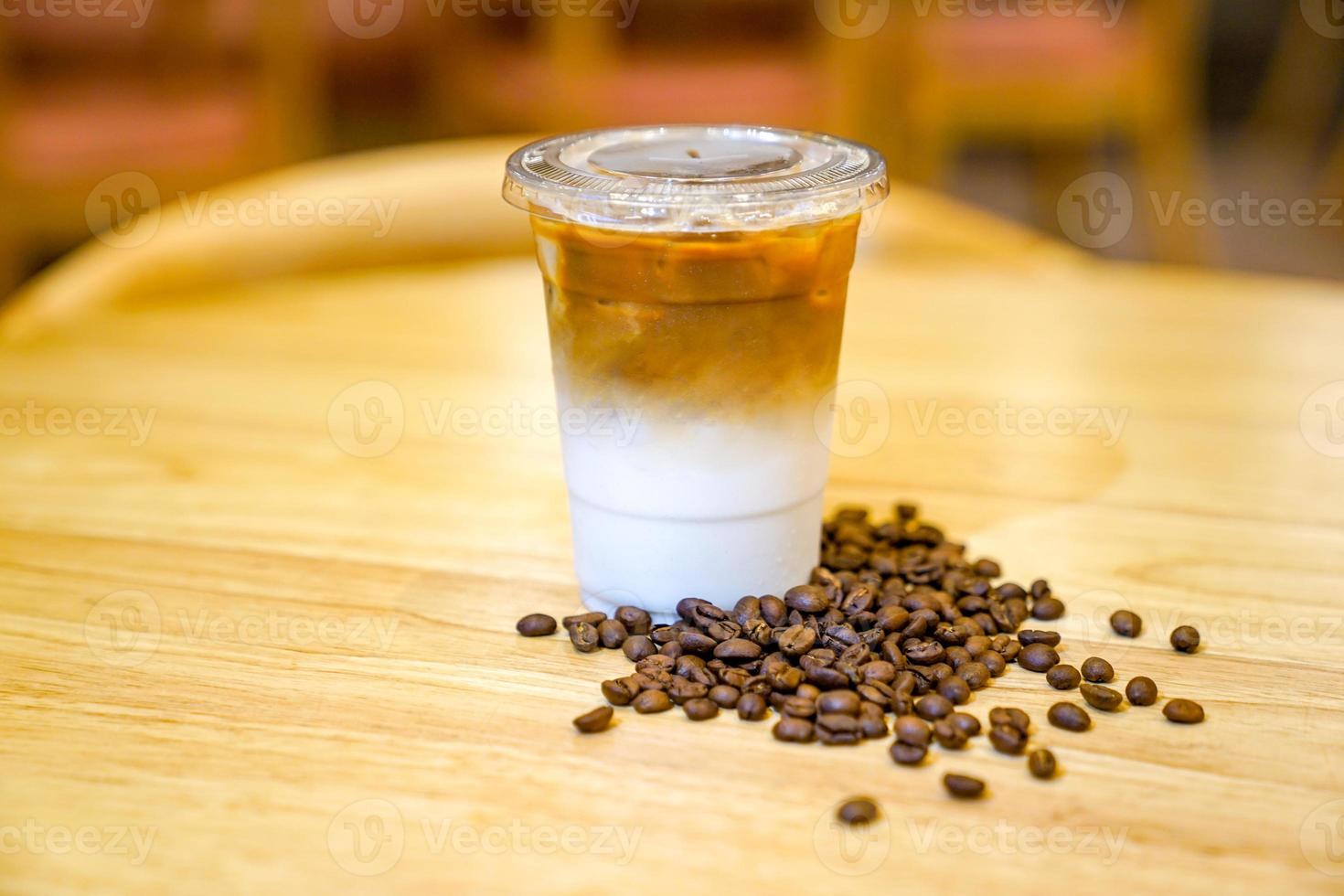 Take away Latte with Coffee bean around on the wood table photo