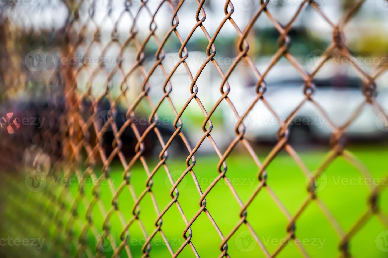 Rust steel net with blur football field. photo