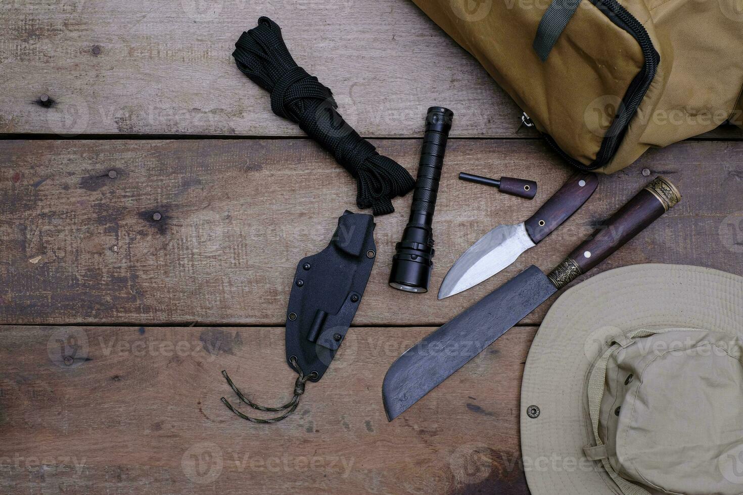 A knife with equipment for survival in the forest  on an old wooden floor photo