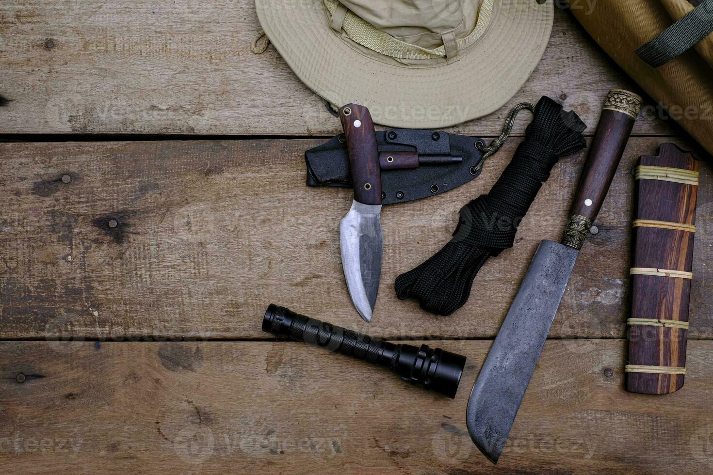 A knife with equipment for survival in the forest  on an old wooden floor photo