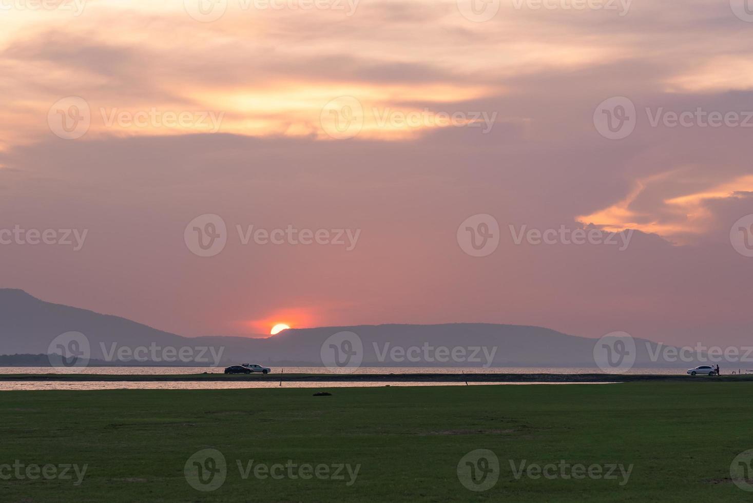 el coche fue conducido en un prado verde cerca del lago al atardecer durante las vacaciones de verano foto