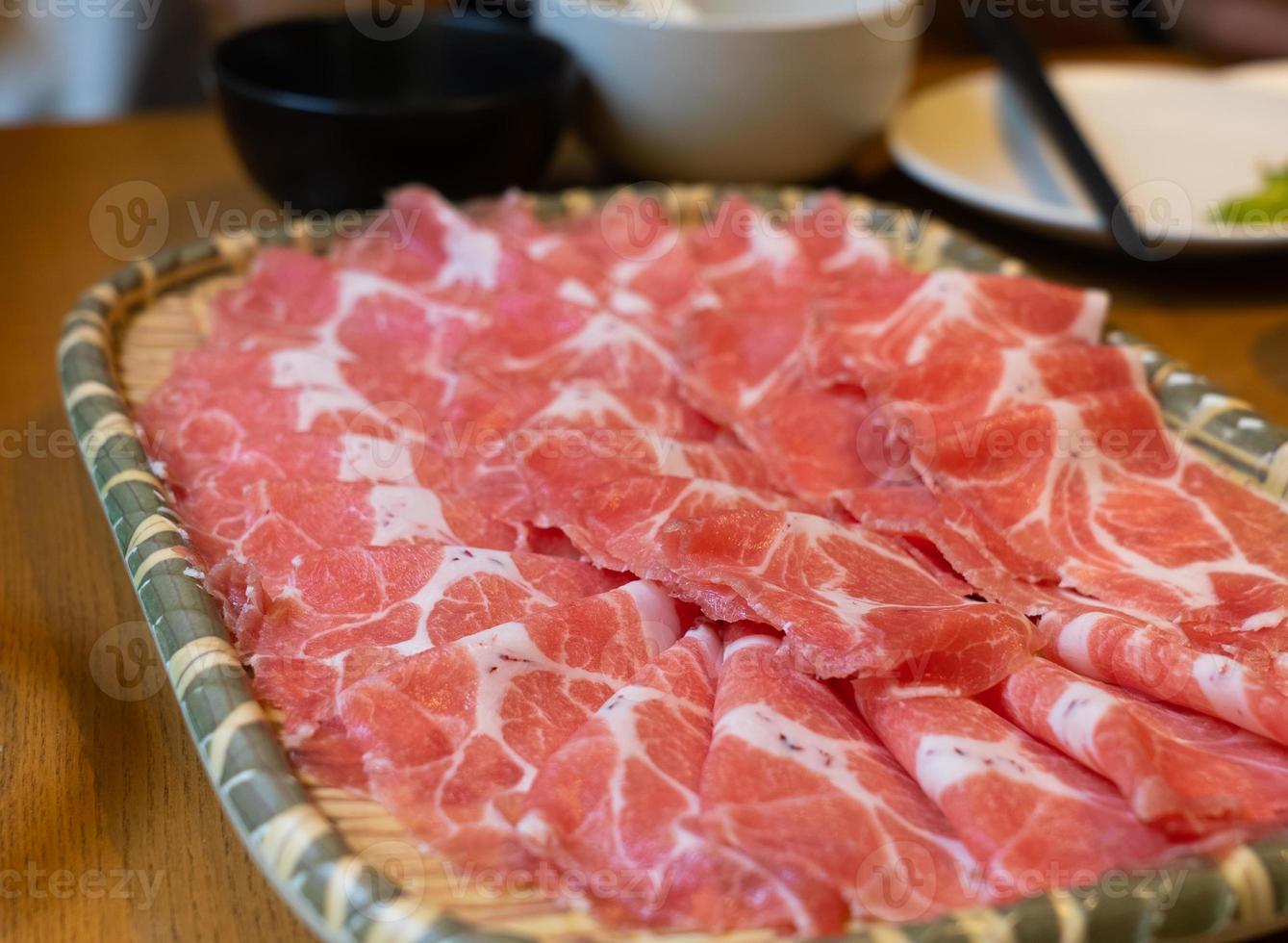 vista de cerca de prok deslizado crudo fresco preparándose para cocinar sukiyaki foto