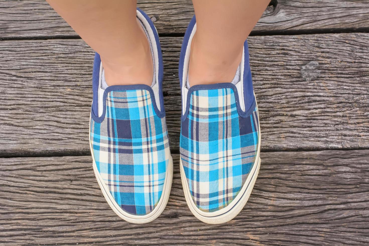 Canvas sneakers on feet on the wooden bridge photo