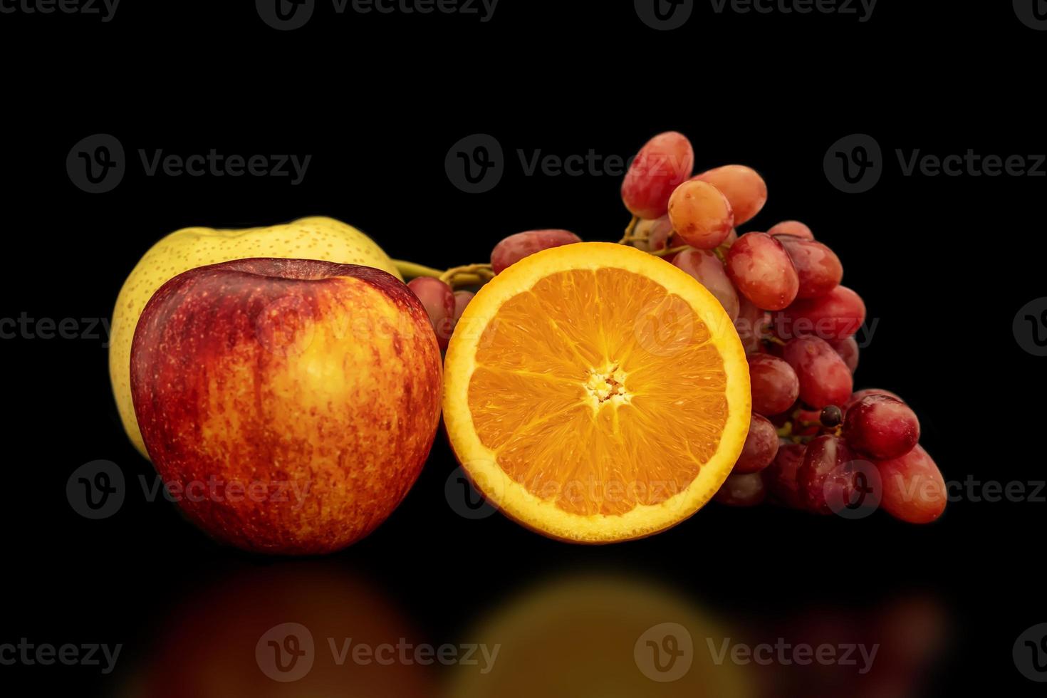 Orange, grapes, apple and pyrus pyriflora on a black background. photo