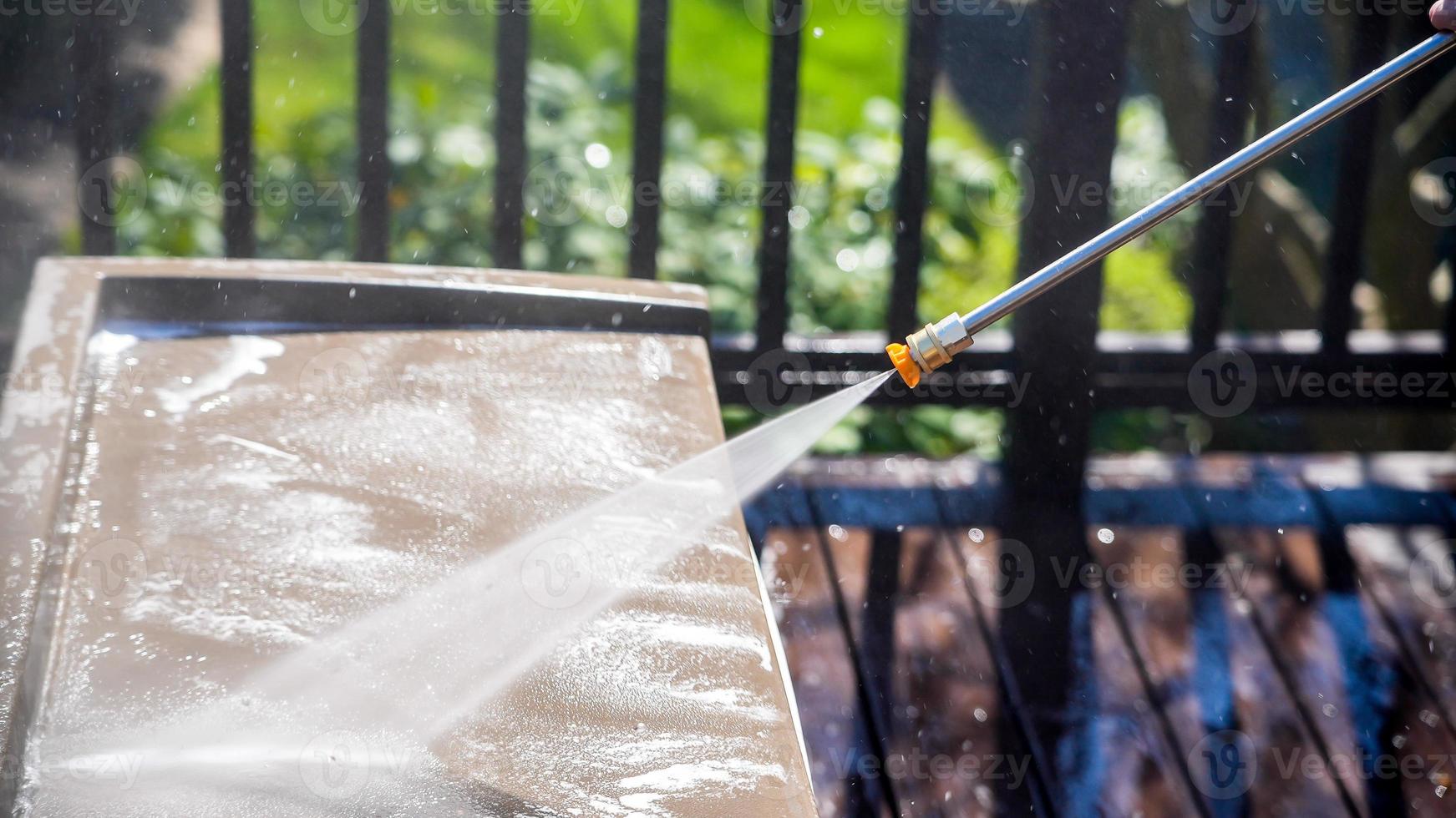 Cleaning plastic box on deck with pressure washer detail photo