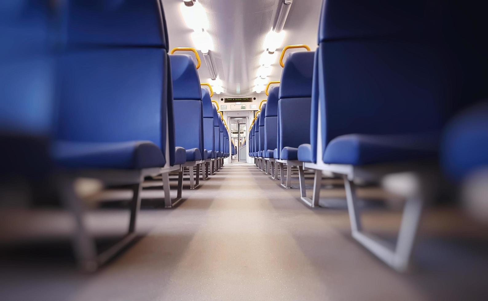 Empty car of passenger train. Free passenger seats in city train. photo