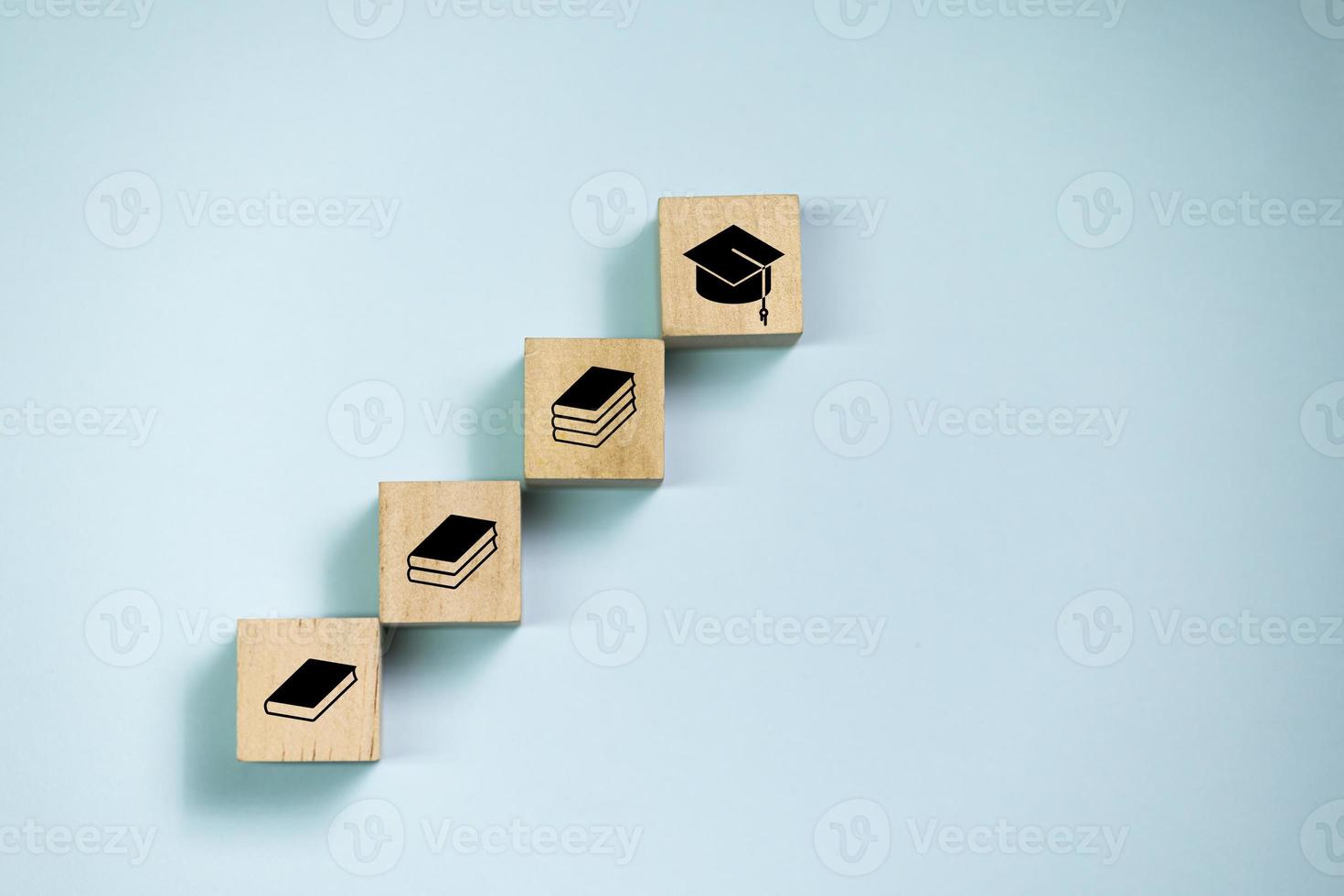 bloques de madera de vista superior ajustados al paso con el icono del libro al icono de posgrado. concepto de aprendizaje y educación. foto