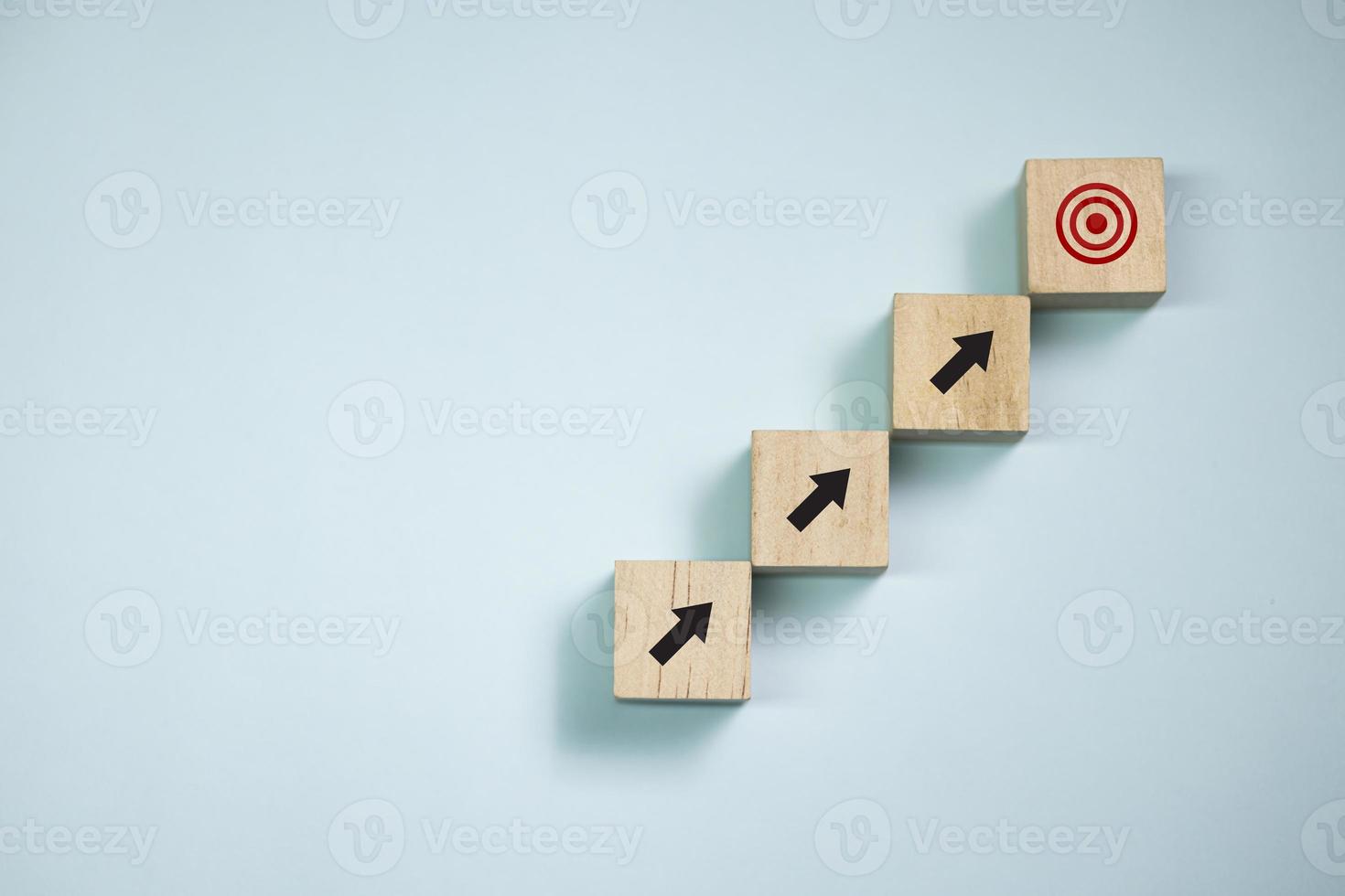 Top view wooden blocks set to step with icon arrow to target. Concept for growth business and targeting. photo