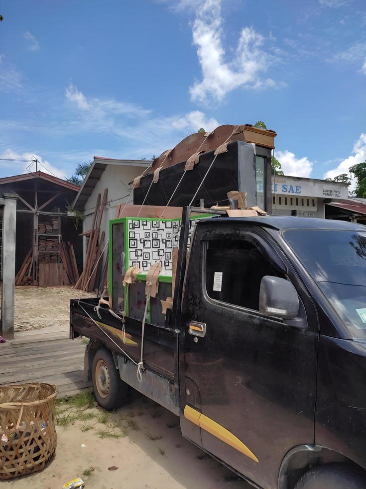 7 May 2022. Riau - Indonesia. a pickup truck that is loading full of goods in the form of a plate rack and a stove table. photo