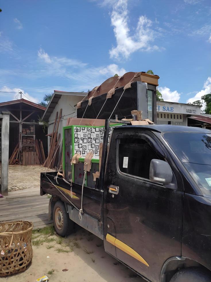 7 mayo 2022. riau - indonesia. una camioneta que se carga llena de mercancías en forma de estante para platos y mesa de cocina. foto