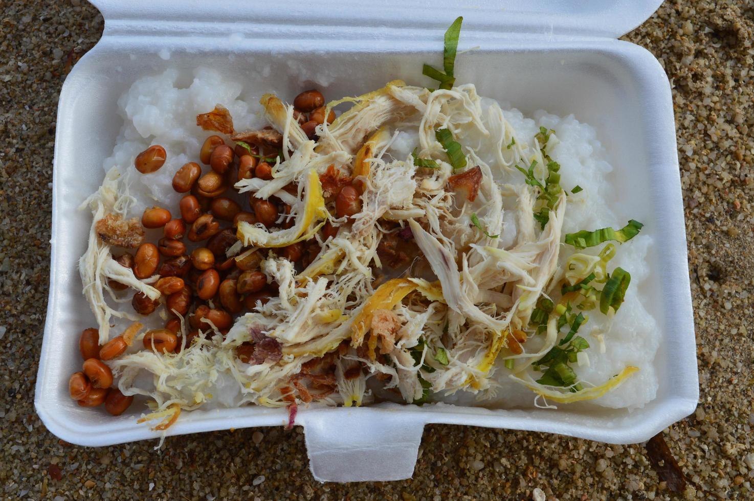 bubur ayam jakarta, bought on the roadside. using a place of styrofoam and with a sand background photo