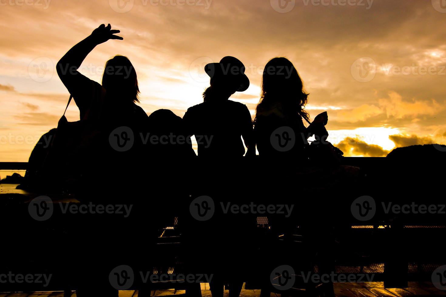 The silhouette of three women at balcony before sunrise photo