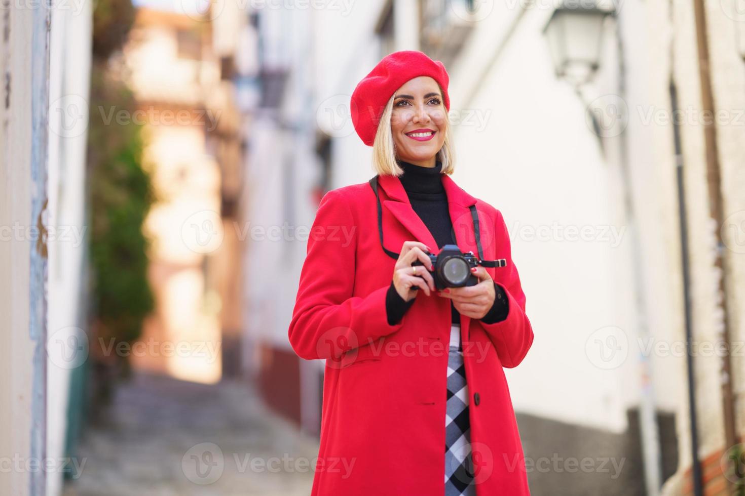 Happy female tourist taking photos of town streets