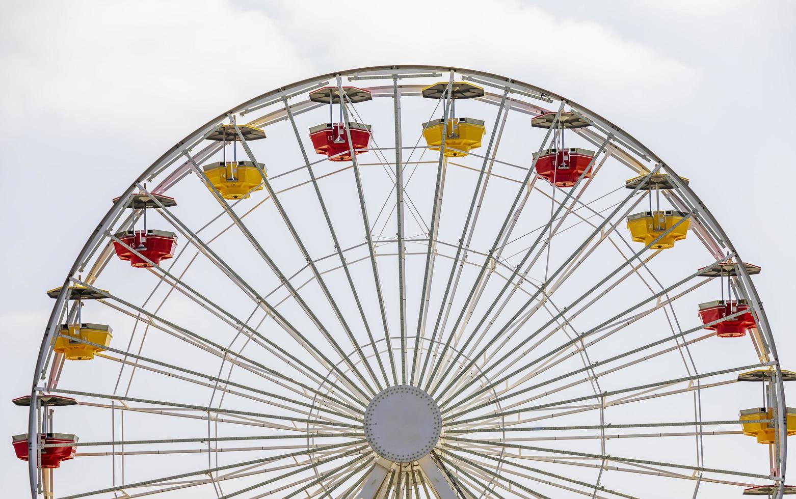 Yellow and red carts on a large white Ferris wheel photo