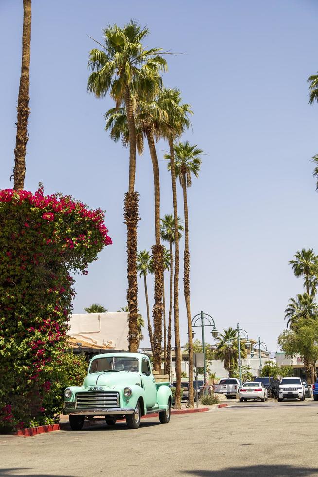 Old vintage blue truck on a street with palm trees photo