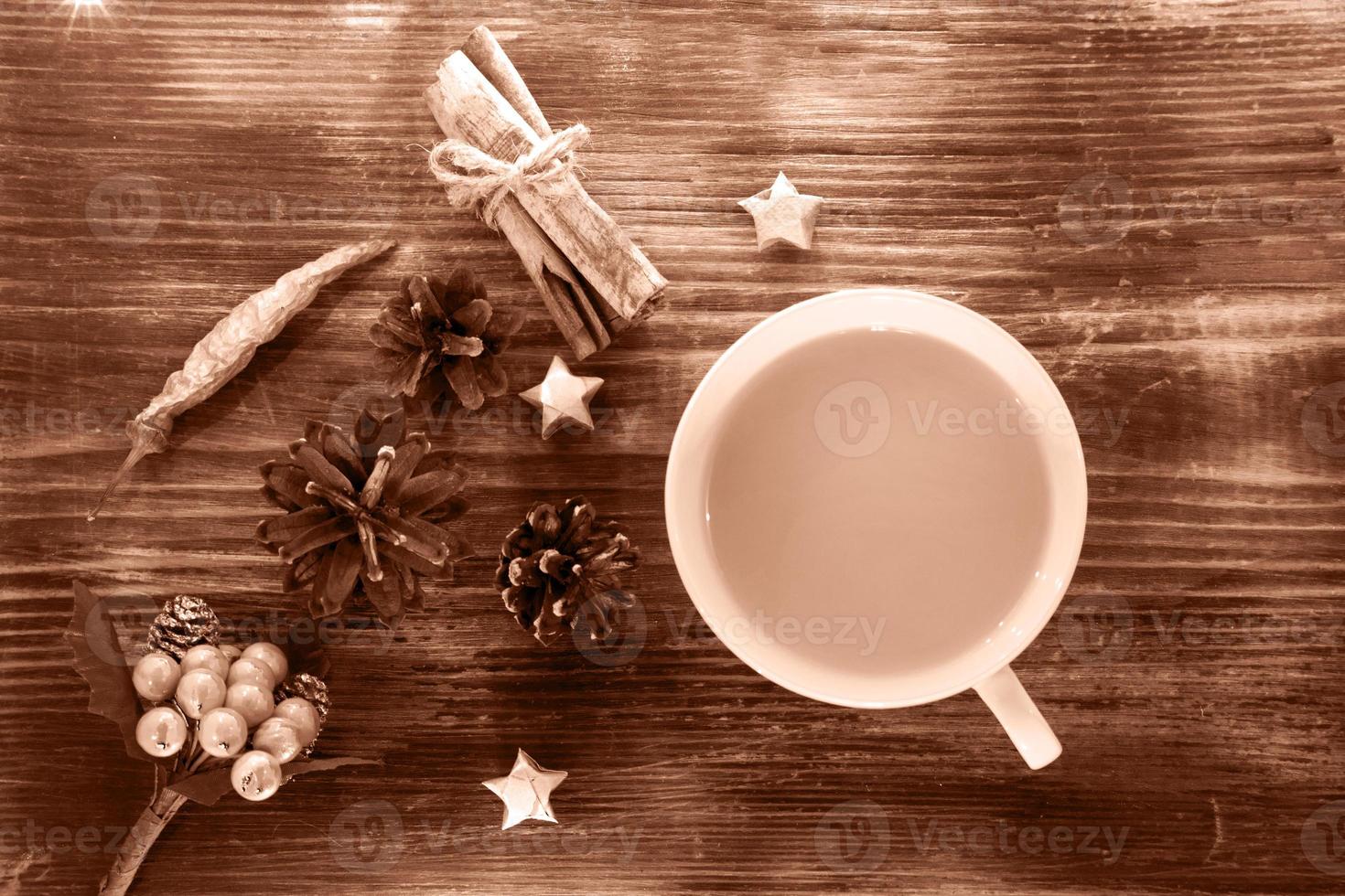 Coffee, spices and pine cones on a wooden background. Christmas concept. A cup of hot coffee with milk, cinnamon and chili on a wooden table. photo