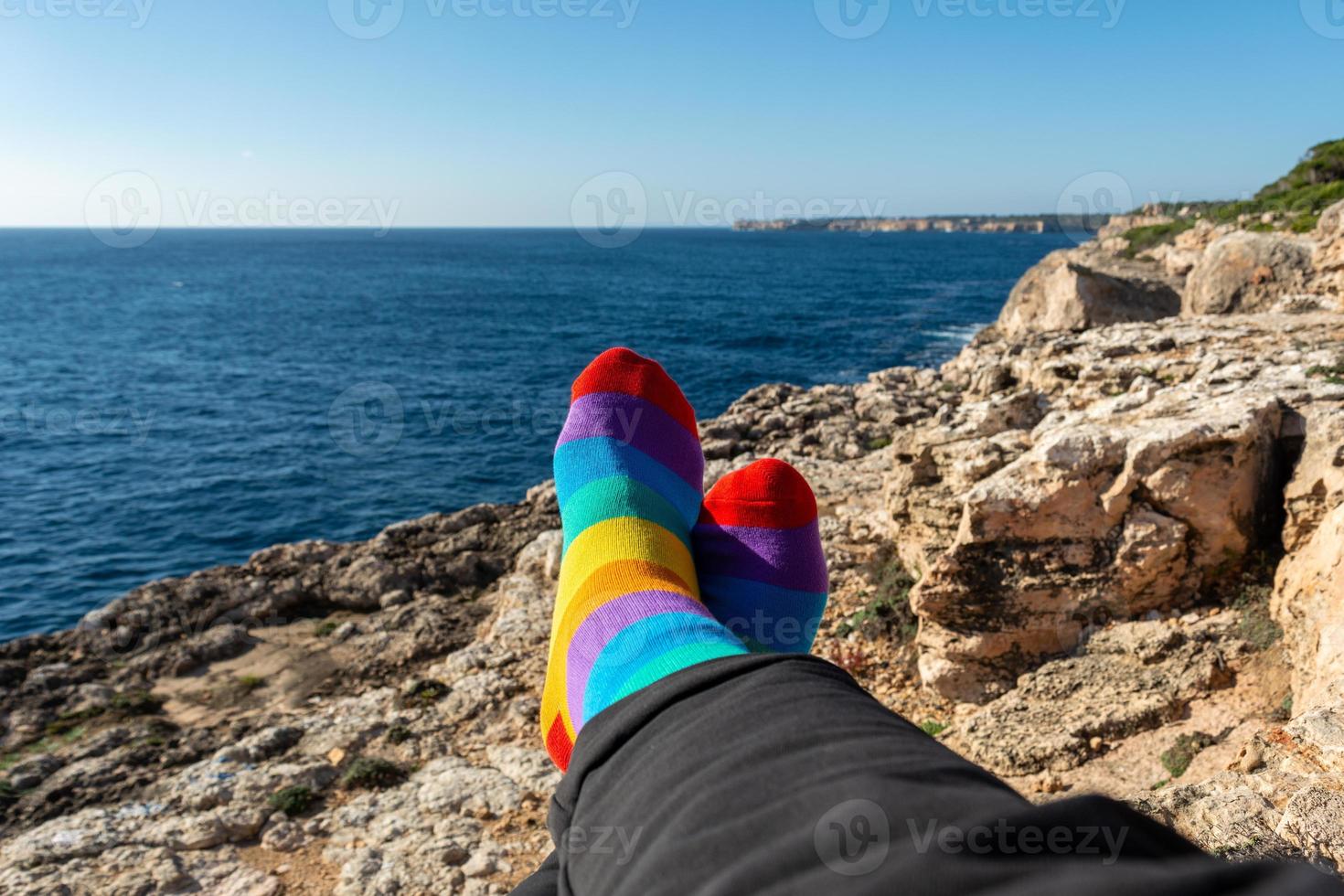 socks with the colors of the flag of the lgtb community. relaxed in front of the sea. Pride concept with copy space photo