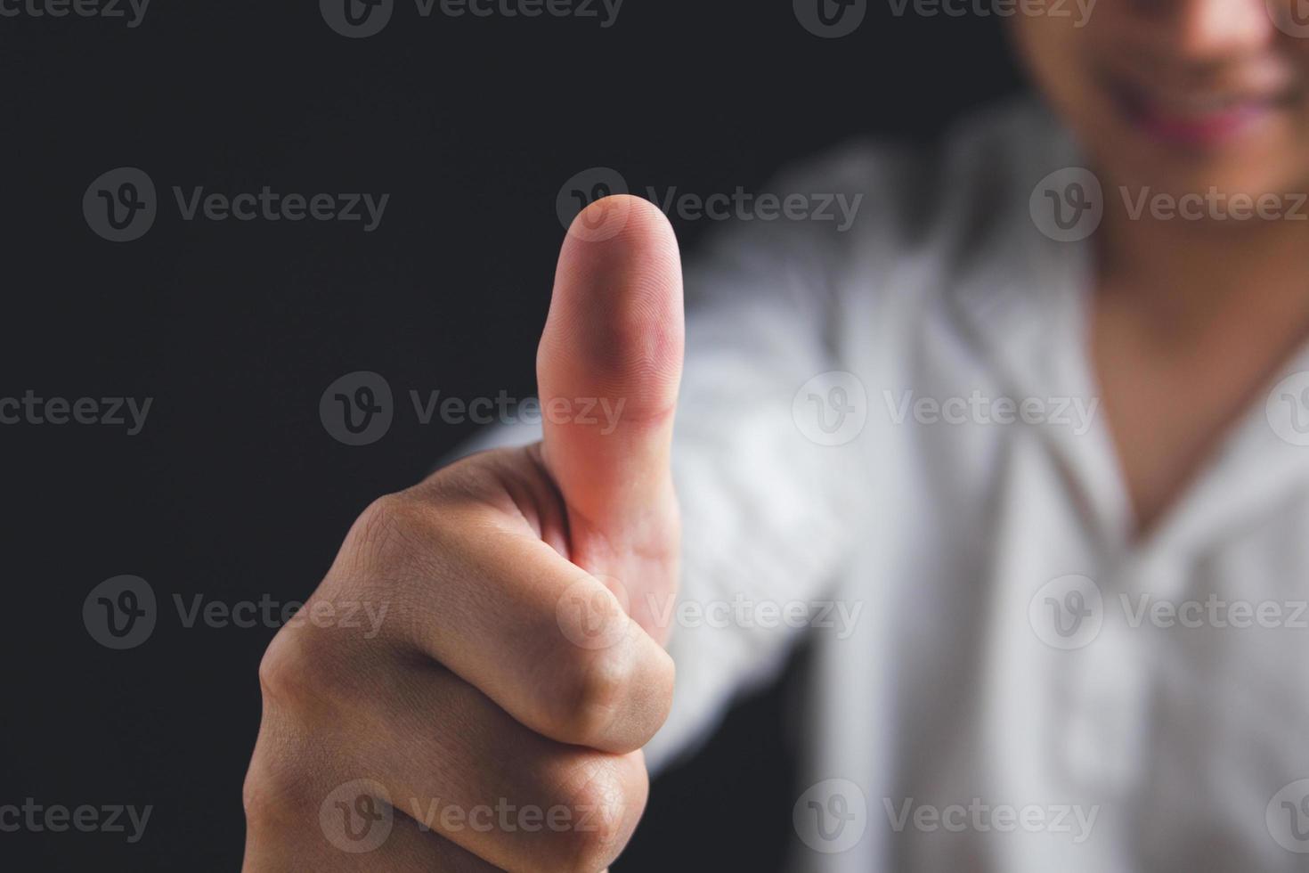 Person that white shirt shows thumbs up sign. Salary man or business man smiles. Like or good concept. Close up shot with copy space. photo