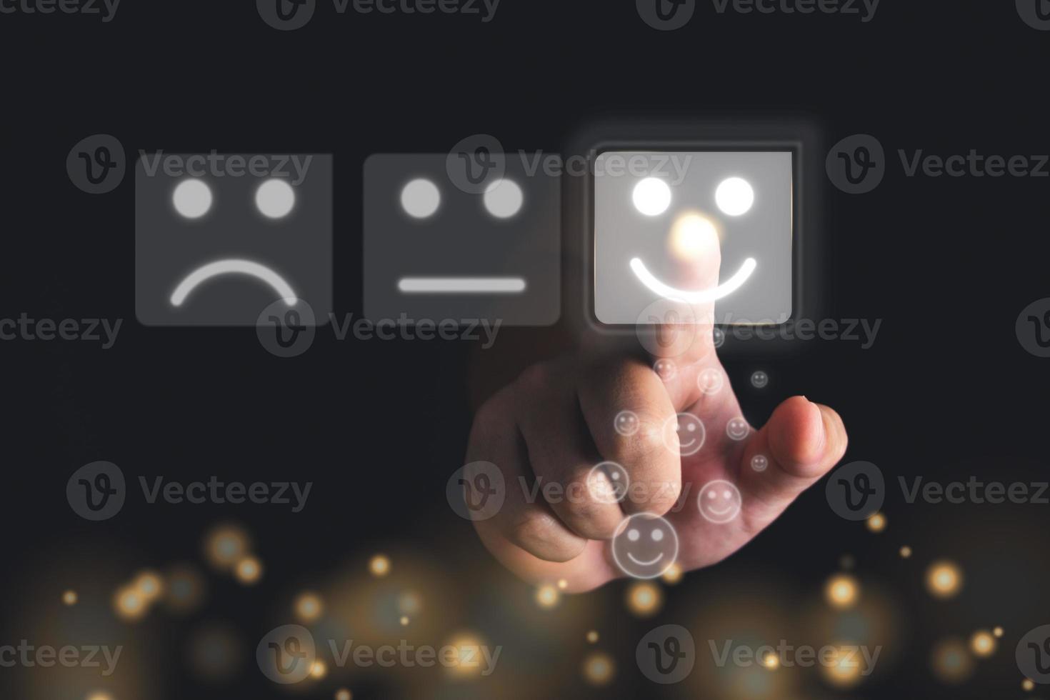 Evaluation and satisfaction concept. Index Finger of hand points to smile emotion that shows an excellent job. Close up shot with gold bokeh glitter on black background. photo