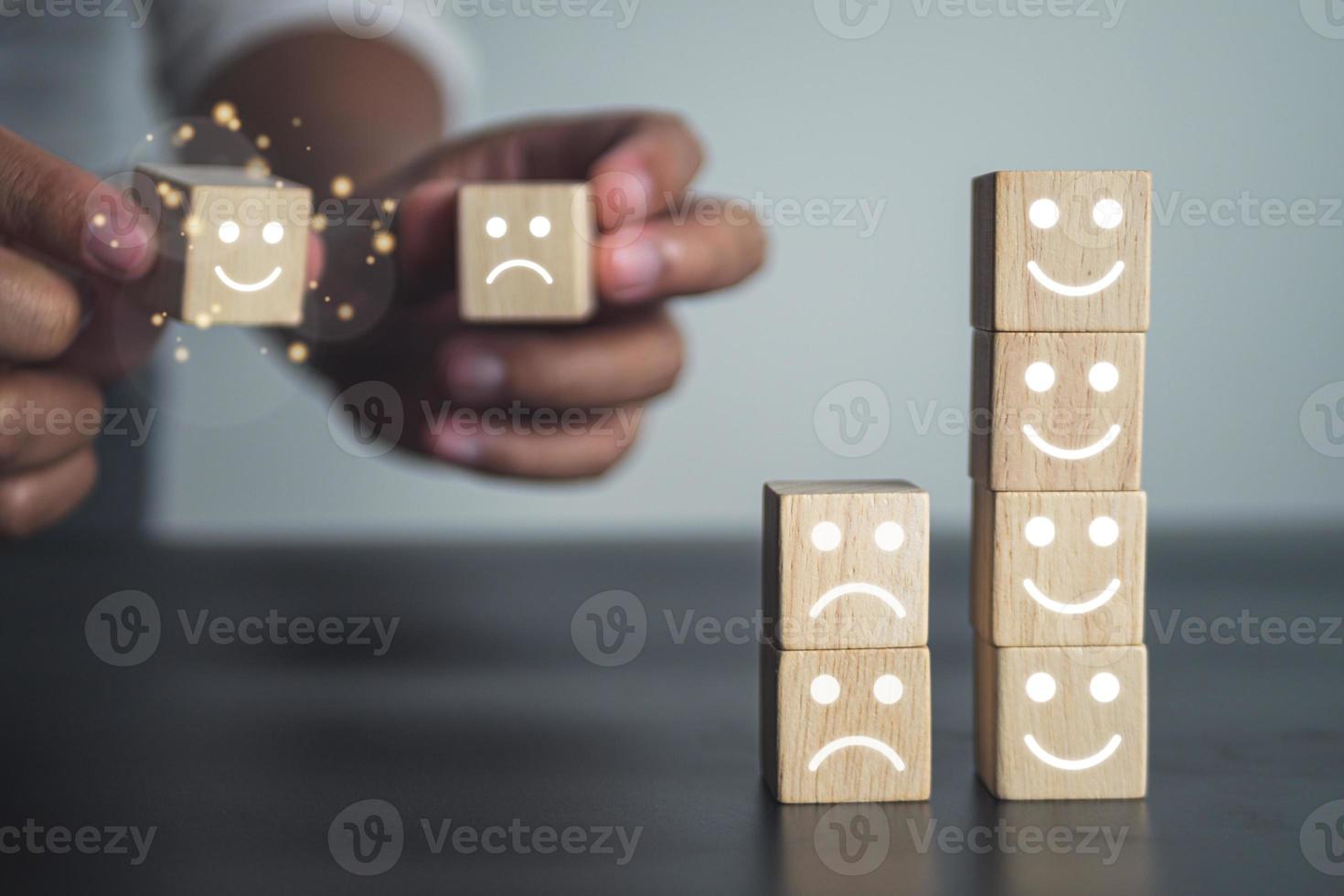 concepto de evaluación y satisfacción. comparación de trabajo bueno y malo. primer plano en bloque de madera con cara de emoji. foto