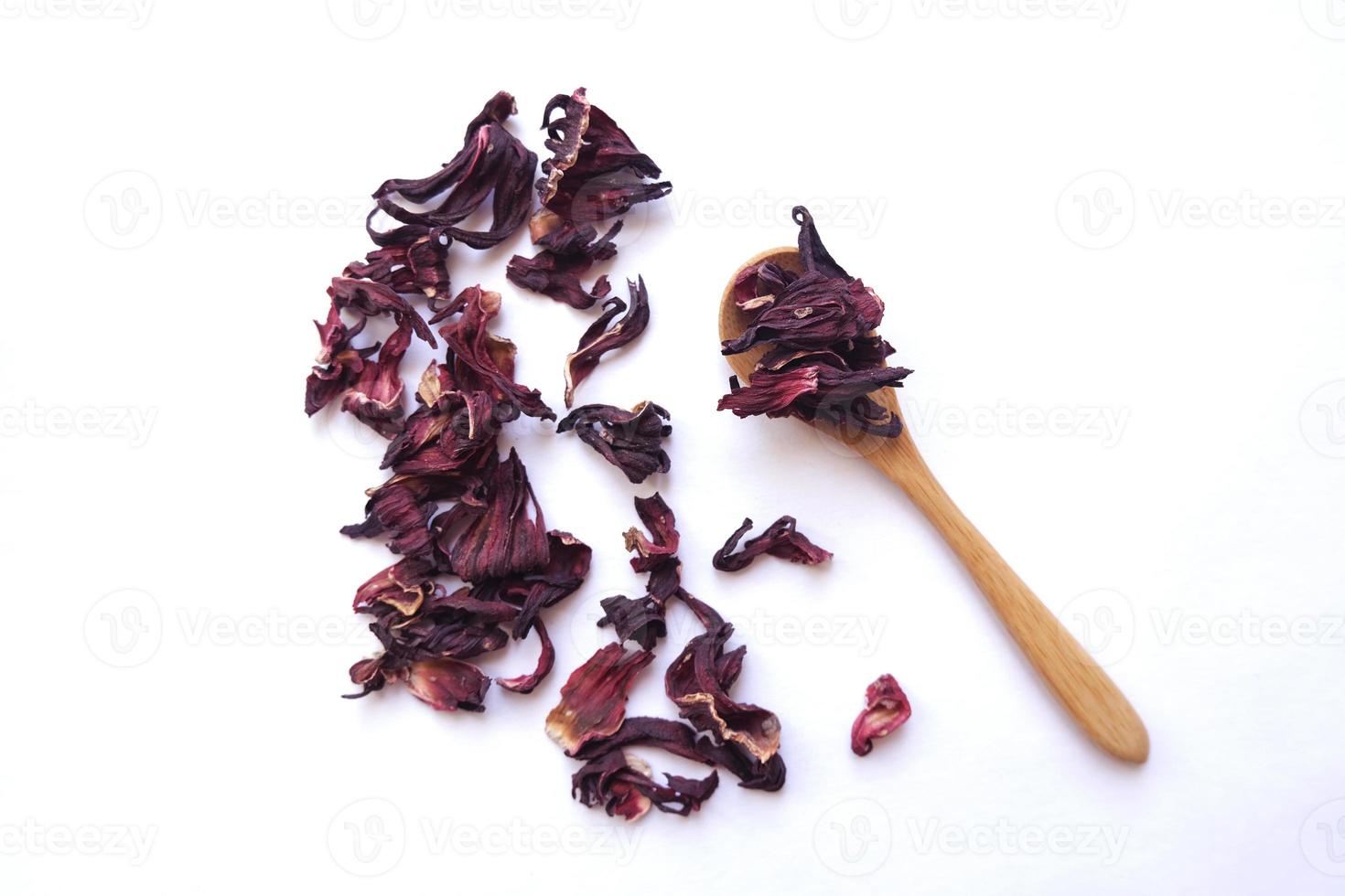 Red dried hibiscus flower leaves in a little wooden spoon, floral tea healthy drink, eco-friendly concept photo