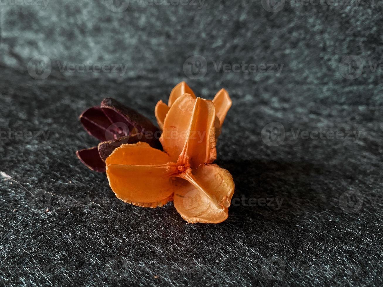 Artificial flowers for interior design on textured gray background. Orange and purple petals, close-up, floral image. Home and office decorations, horizontal photo