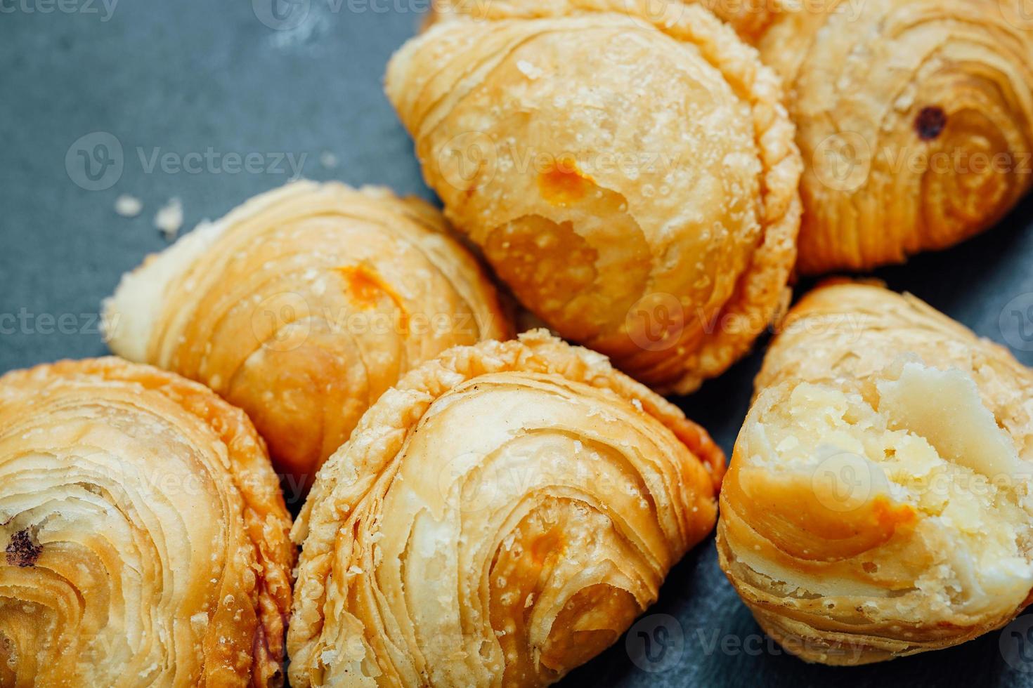 Curry puff pastry in a stone plate placed on a wooden table. photo