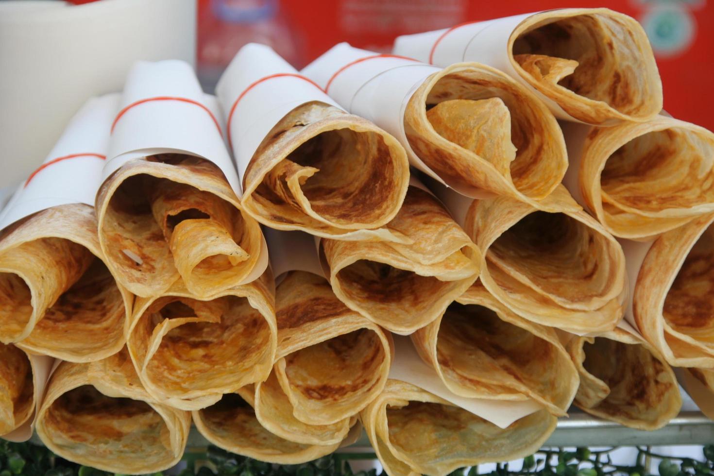 pila de papel cubierto de roti tailandés crujiente, preparado para la venta. foto