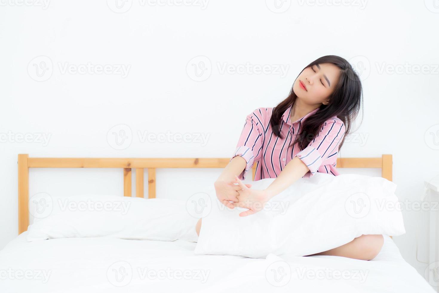 Beautiful of portrait young asian woman stretch and relax in bed after wake up morning at bedroom, new day and resting for wellness, lifestyle concept. photo