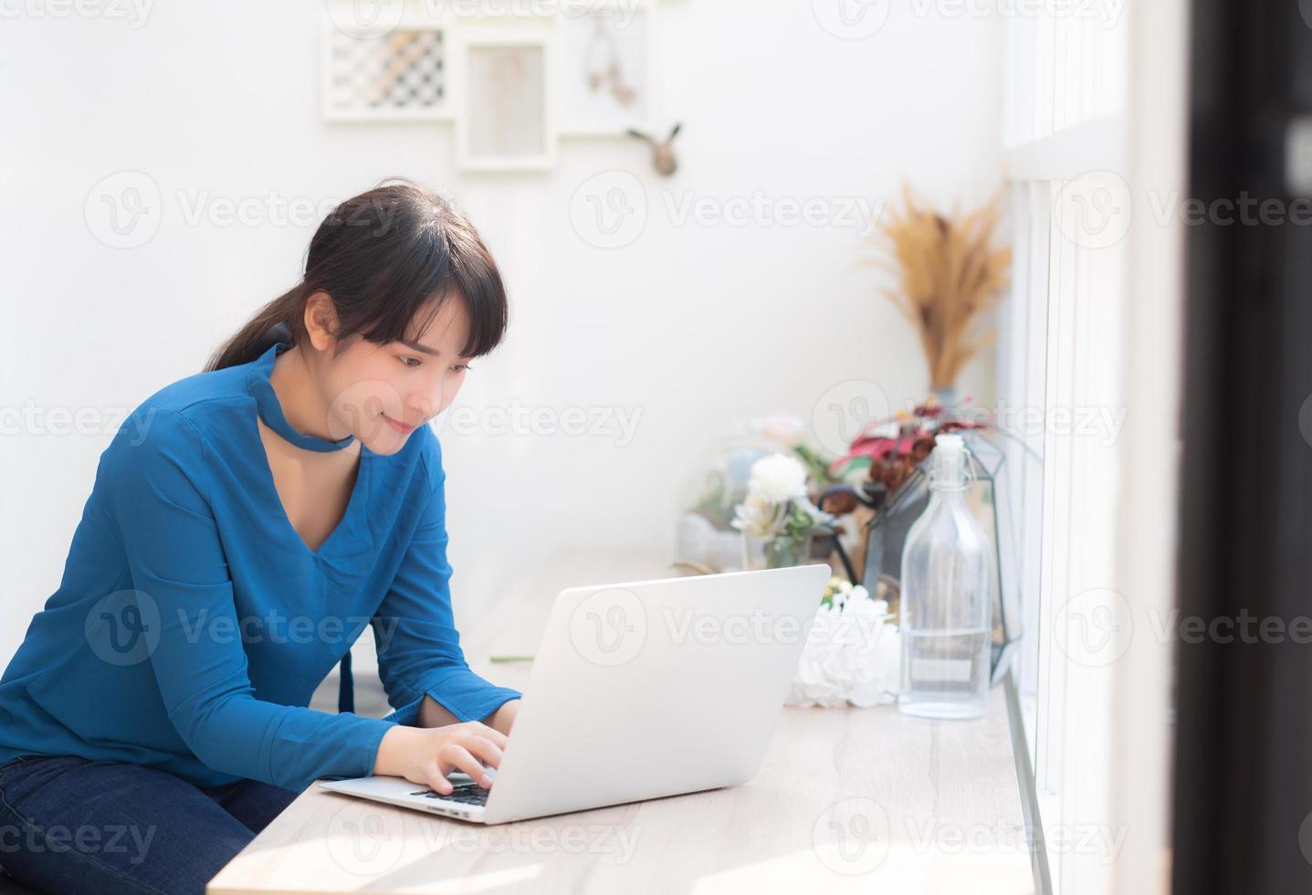 Beautiful portrait asia young woman working online on laptop sitting at cafe shop, professional female freelance using notebook computer, business and communication concept. photo