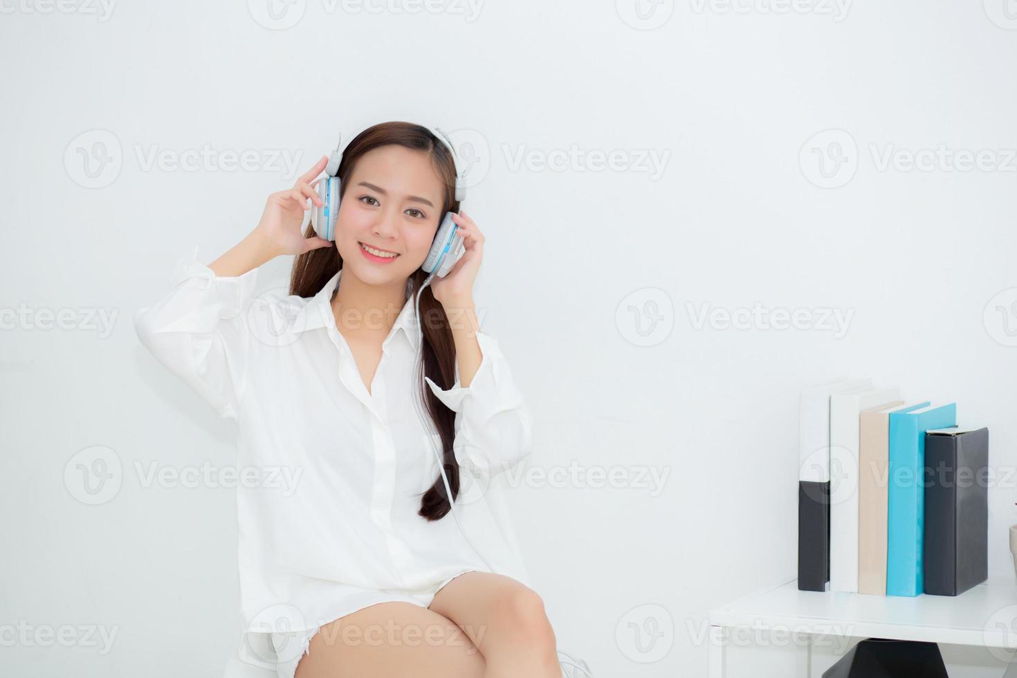 hermoso retrato mujer joven asiática feliz disfrutar y divertirse escuchar música con auriculares sentados en la sala de estar, estilo de vida de niña relajarse radio de sonido con auriculares, concepto de ocio y tecnología. foto