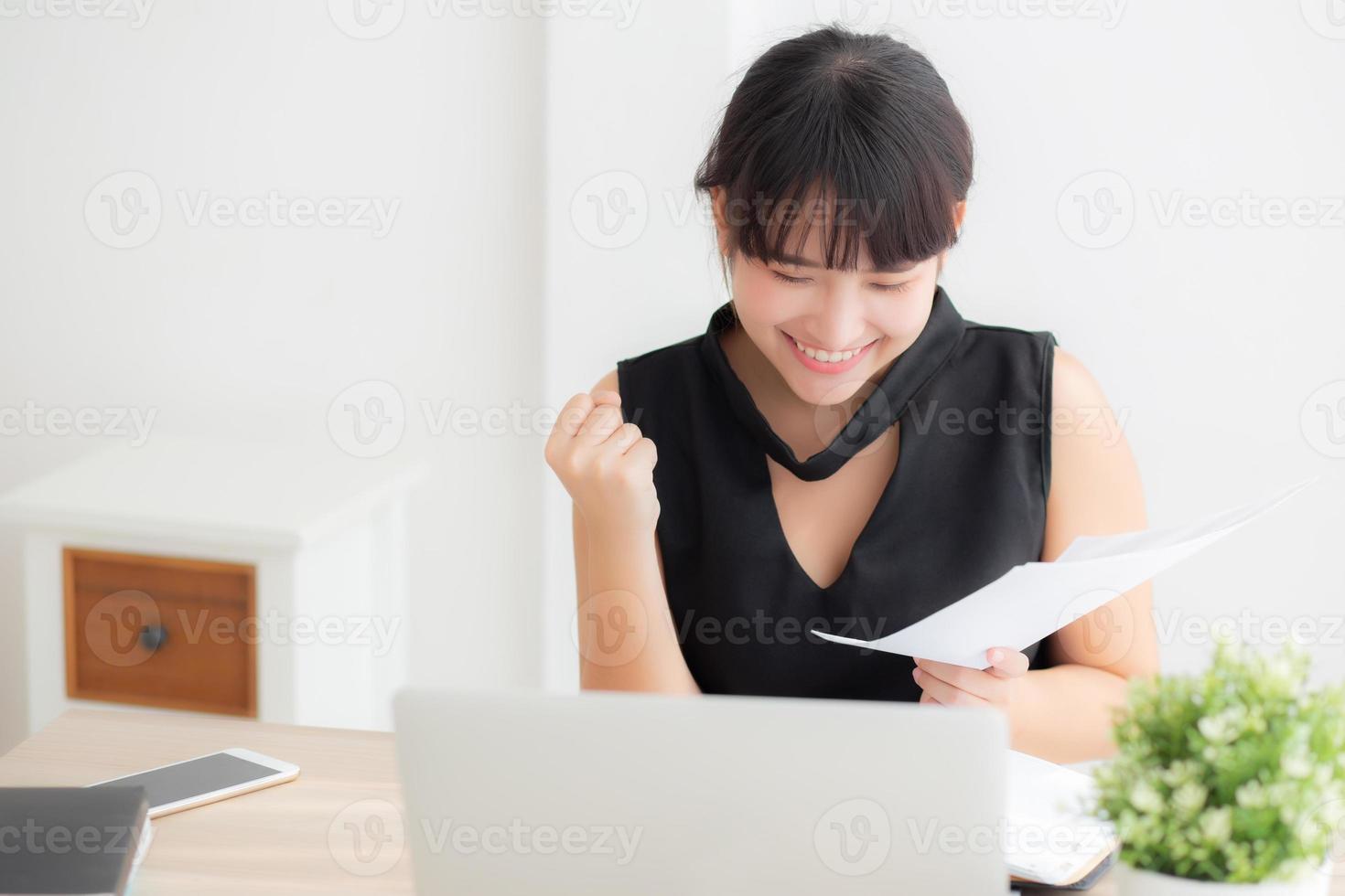 Beautiful young asian woman working laptop computer at office, businesswoman looking graph diagram analysis statistic data with excited and success, girl using notebook, business concept. photo
