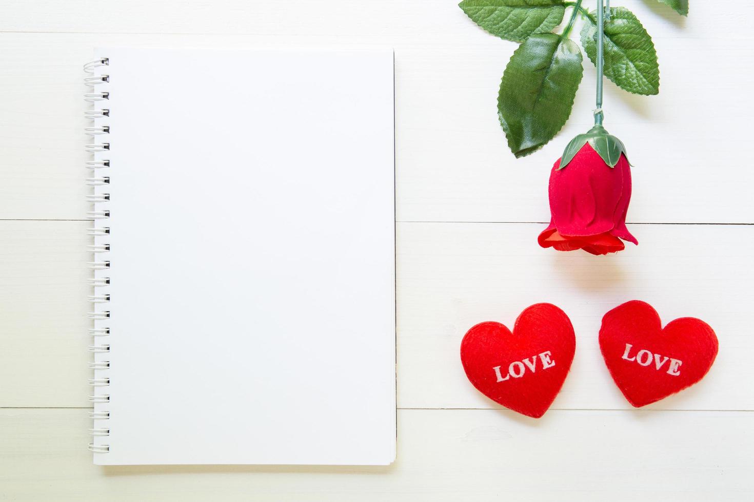 Present red rose flower and notebook and heart shape with copy space on wooden table, 14 February of love day with romantic, valentine holiday concept. photo