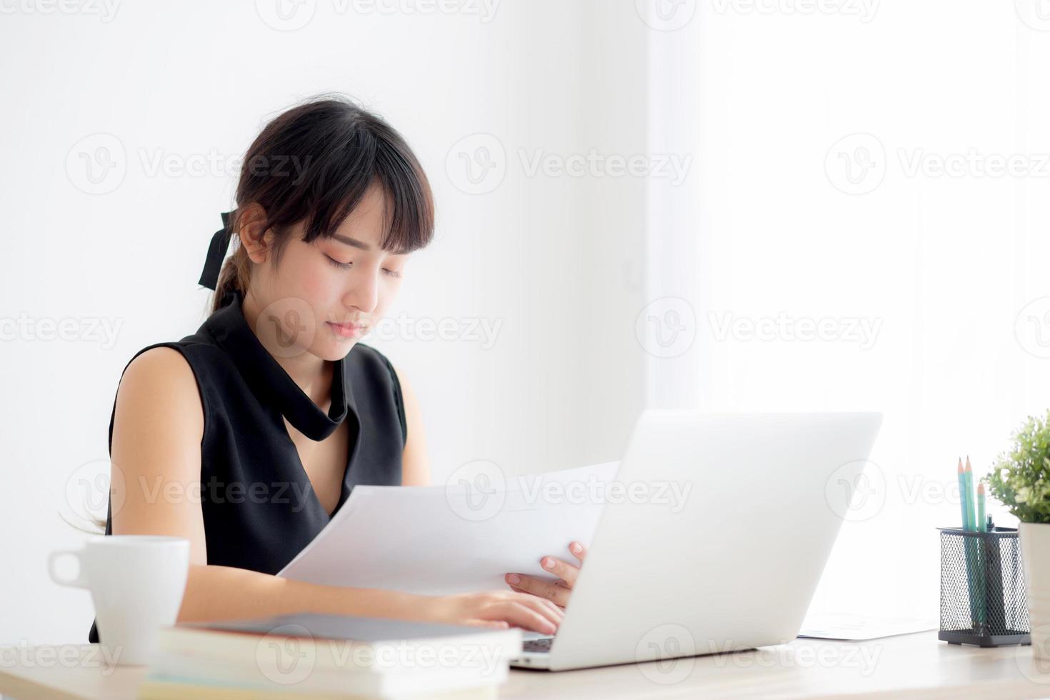 Young asian woman working and typing with laptop computer at office, businesswoman looking graph diagram analysis statistic data of finance, girl using notebook, profit growth, business concept. photo