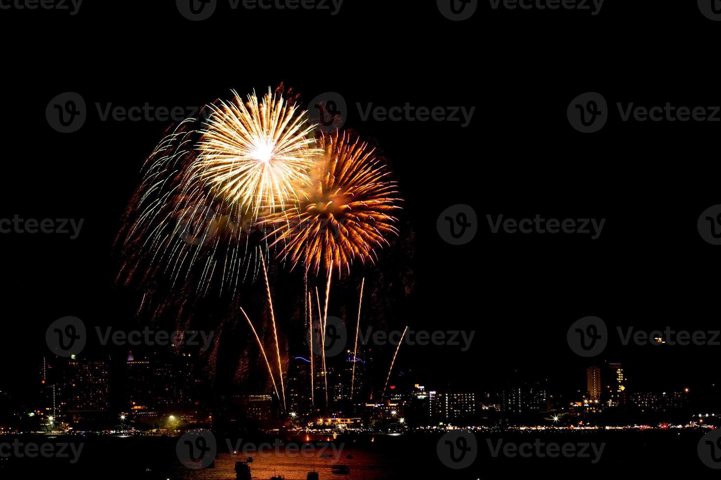 Many flashing fireworks with night cityscape background celebrate New Year. photo