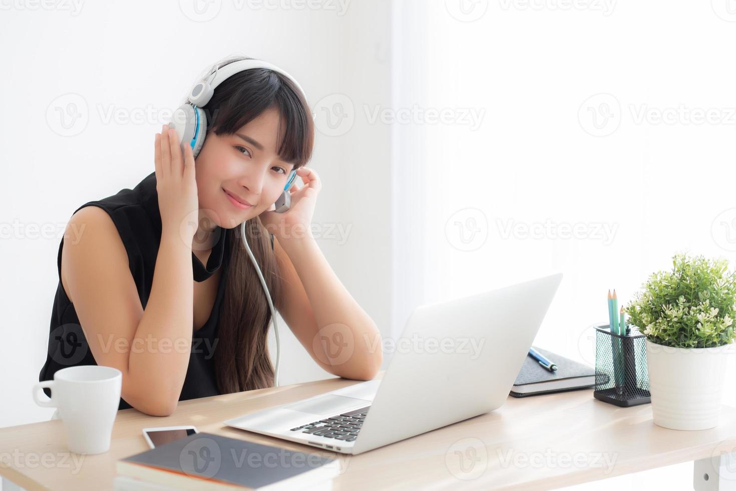 Beautiful young asian woman wear headphone smiling say hello using chat video call on laptop computer, girl relax enjoy listening music online, education learning, communication and lifestyle concept. photo