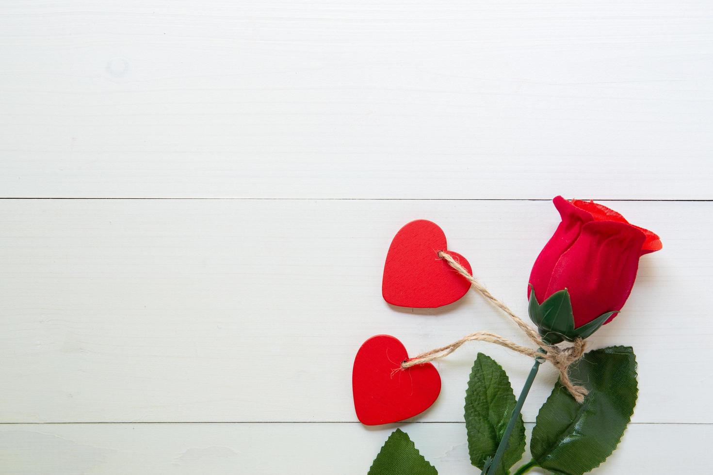 Present gift with red rose flower and heart shape on wooden table, 14 February of love day with romantic copy space, valentine holiday concept, top view. photo