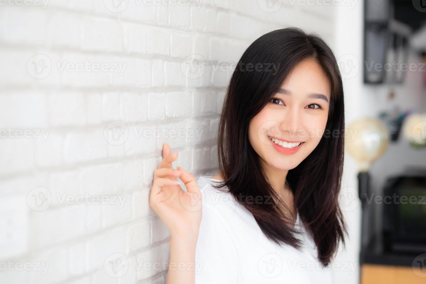 retrato de la hermosa joven mujer asiática felicidad de pie sobre fondo de ladrillo de pared de grunge de textura de cemento gris, mujer de negocios es una sonrisa en concreto, concepto de gente de negocios. foto